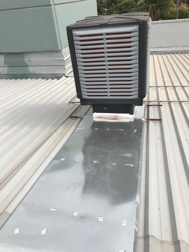 Climatizadores evaporativos alinhados em cobertura industrial